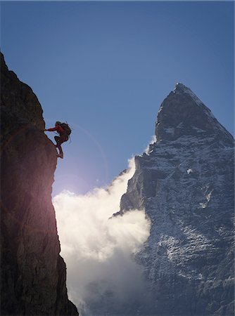 silhouette person outdoors mountains - Silhouetted female climber climbing rock face near Matterhorn, Canton Wallis, Switzerland Stock Photo - Premium Royalty-Free, Code: 649-08840480