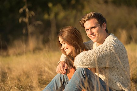 simsearch:649-08239088,k - Young couple sitting in rural setting, smiling Stock Photo - Premium Royalty-Free, Code: 649-08840572