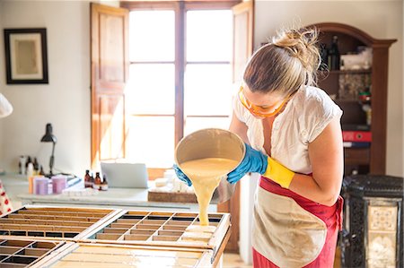 self-employed - Young woman pouring liquid lavender soap into moulds in handmade soap workshop Stock Photo - Premium Royalty-Free, Code: 649-08859559