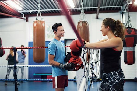 Female boxer leaning on boxing ring ropes talking to male boxer Stock Photo - Premium Royalty-Free, Code: 649-08859808