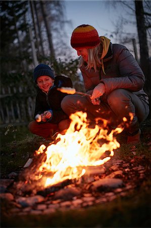 simsearch:649-06943770,k - Mature woman and son toasting marshmallows on garden campfire at dusk Foto de stock - Sin royalties Premium, Código: 649-08859991