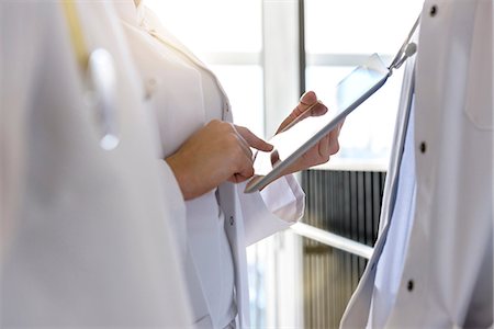 Mid section female doctors using digital tablet touchscreen in hospital Stock Photo - Premium Royalty-Free, Code: 649-08860196