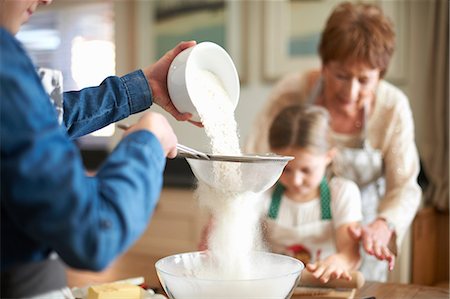 simsearch:614-08270379,k - Senior woman and granddaughters sifting flour for cookies Stock Photo - Premium Royalty-Free, Code: 649-08860514