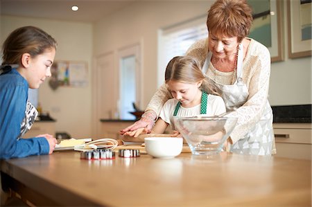simsearch:614-08270379,k - Senior woman and granddaughters rolling dough for Christmas tree cookies Stock Photo - Premium Royalty-Free, Code: 649-08860511