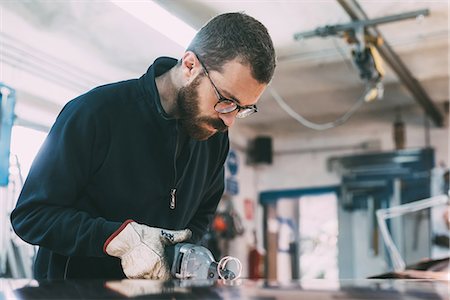 forge - Metalworker gouging sheet copper at forge workbench Stock Photo - Premium Royalty-Free, Code: 649-08894157