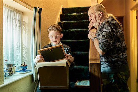 past - Senior man explaining to grandson sitting on stairs with photograph frame Photographie de stock - Premium Libres de Droits, Code: 649-08894186