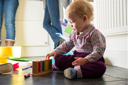 simsearch:649-07280933,k - Baby girl sitting on kitchen floor playing with toys Foto de stock - Sin royalties Premium, Código: 649-08894681