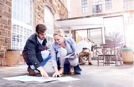 Businesswoman and man looking at paperwork on office patio floor Stock Photo - Premium Royalty-Free, Code: 649-08894699
