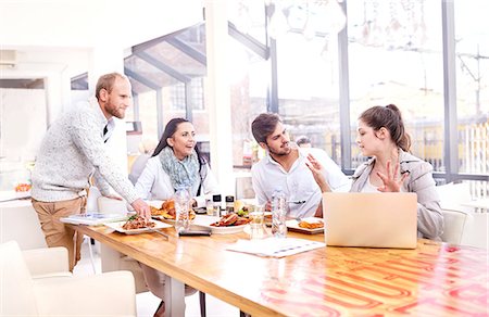 Businesswoman explaining to business team during working lunch in restaurant Stock Photo - Premium Royalty-Free, Code: 649-08894707