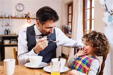 simsearch:6113-07242957,k - Man feeding daughter cereal with hand over mouth in kitchen Stock Photo - Premium Royalty-Free, Code: 649-08894921