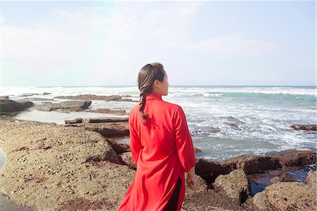 simsearch:614-08392638,k - Woman wearing red dress, standing on rocks, looking at sea view, South Africa Stock Photo - Premium Royalty-Free, Code: 649-08895025