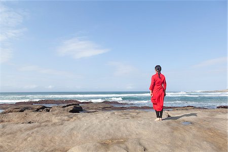 simsearch:614-08392638,k - Woman wearing red dress, standing on rocks, looking at sea view, South Africa Stock Photo - Premium Royalty-Free, Code: 649-08895026