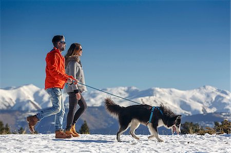 simsearch:400-05724021,k - Couple walking dog in snow covered mountain landscape Stock Photo - Premium Royalty-Free, Code: 649-08900384