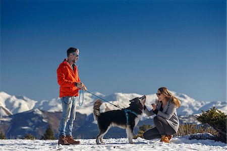 simsearch:400-05724021,k - Couple petting dog in snow covered mountain landscape Stock Photo - Premium Royalty-Free, Code: 649-08900386