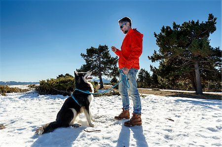 simsearch:400-05724021,k - Mature man training dog in snow covered landscape Stock Photo - Premium Royalty-Free, Code: 649-08900388