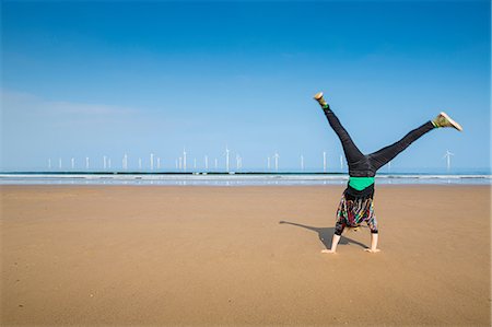 simsearch:649-03009497,k - Mature woman doing cartwheel on Redcar beach, North Yorkshire, UK Stock Photo - Premium Royalty-Free, Code: 649-08900663