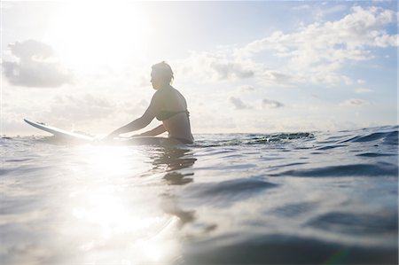 simsearch:649-08900720,k - Woman straddling surfboard in sunlit sea, Nosara, Guanacaste Province, Costa Rica Stock Photo - Premium Royalty-Free, Code: 649-08900722