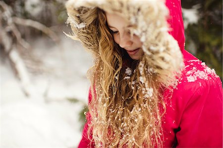 Girl in parka with snow in her hair looking down Stock Photo - Premium Royalty-Free, Code: 649-08900938