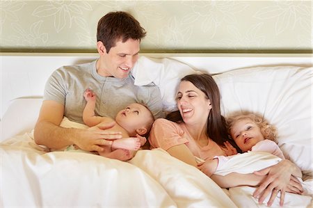simsearch:649-08422552,k - Baby girl and toddler sister huddled in bed with parents Foto de stock - Sin royalties Premium, Código: 649-08900979