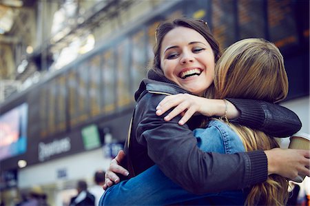 friends laughing - Women hugging in train station concourse, London, UK Stock Photo - Premium Royalty-Free, Code: 649-08901073