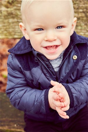 Portrait of blue eyed male toddler on park bench Foto de stock - Sin royalties Premium, Código: 649-08901200