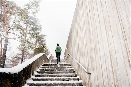 simsearch:649-07437947,k - Rear view of young female runner in knit hat running up snow covered stairway Stock Photo - Premium Royalty-Free, Code: 649-08901229