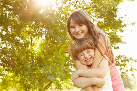 simsearch:649-06401393,k - Portrait of girl being hugged by big sister in park Stock Photo - Premium Royalty-Free, Code: 649-08901502