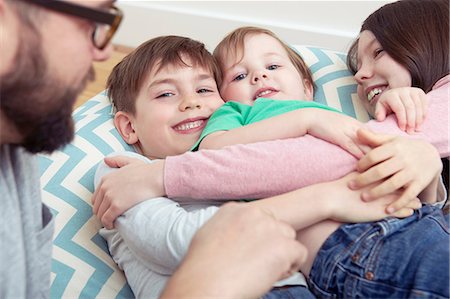 simsearch:632-03848361,k - Father and three smiling children reclining on beanbag chair Stock Photo - Premium Royalty-Free, Code: 649-08901516