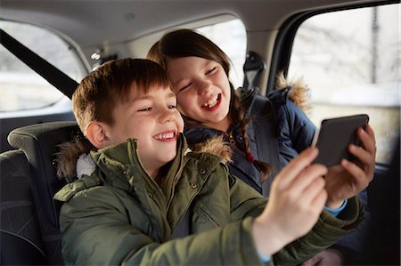 simsearch:649-07804673,k - Boy and sister taking laughing selfie in car backseat Photographie de stock - Premium Libres de Droits, Code: 649-08901568