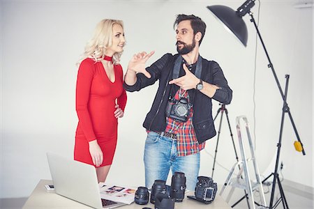 Male photographer explaining to female model for studio photo shoot Stock Photo - Premium Royalty-Free, Code: 649-08902178