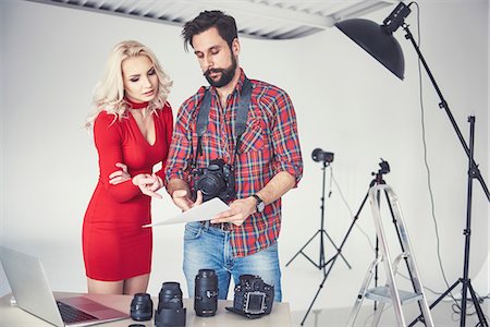 photographers taking pictures of models - Male photographer and model looking at photographs from photo shoot in studio Stock Photo - Premium Royalty-Free, Code: 649-08902179