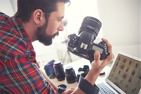 fotógrafo - Male photographer  reviewing photo shoot on laptop in studio Foto de stock - Sin royalties Premium, Código: 649-08902172