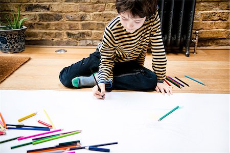 Boy sitting on floor drawing on large paper Stock Photo - Premium Royalty-Free, Code: 649-08902220