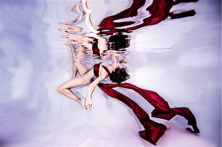 Underwater view of poised woman with wearing flowing red textiles Stock Photo - Premium Royalty-Free, Code: 649-08902245