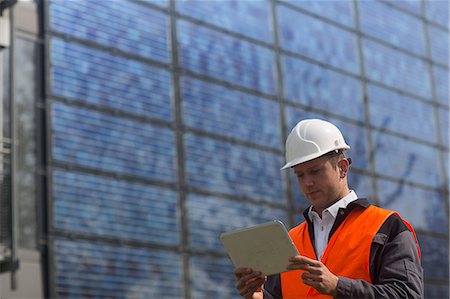 environmental sciences 20s - Young male engineer looking at digital tablet at solar panel site Stock Photo - Premium Royalty-Free, Code: 649-08924030