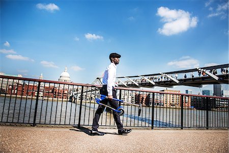 Businessman carrying scooter, Millennium Bridge, London, UK Stock Photo - Premium Royalty-Free, Code: 649-08924112