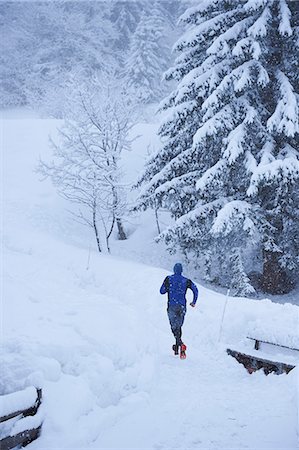 simsearch:649-07437947,k - Rear view of male runner running on track in deep snow, Gstaad, Switzerland Stock Photo - Premium Royalty-Free, Code: 649-08924186