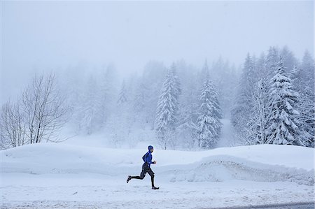 simsearch:649-07437947,k - Distant view of male runner running in deep snow, Gstaad, Switzerland Stock Photo - Premium Royalty-Free, Code: 649-08924198