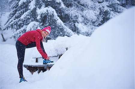 simsearch:649-08924209,k - Portrait of female runner tying trainer laces on park bench in deep snow, Gstaad, Switzerland Stock Photo - Premium Royalty-Free, Code: 649-08924190