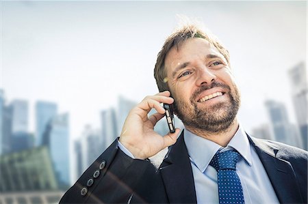 Businessman making smartphone call in city Stock Photo - Premium Royalty-Free, Code: 649-08924226