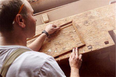 simsearch:649-07710266,k - Over shoulder view of carpenter sanding picture frame at workbench Stock Photo - Premium Royalty-Free, Code: 649-08924257