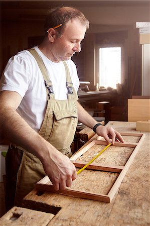 simsearch:6115-07109879,k - Male carpenter measuring frame at workbench Stock Photo - Premium Royalty-Free, Code: 649-08924259