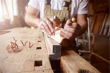 simsearch:649-07710266,k - Mid section of male carpenter using wood plane at workbench Stock Photo - Premium Royalty-Free, Code: 649-08924260