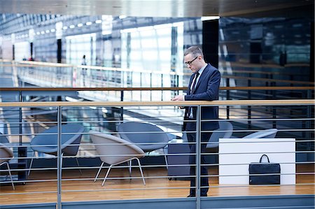 simsearch:649-07520071,k - Businessman looking at smartphone on office balcony Stock Photo - Premium Royalty-Free, Code: 649-08924373