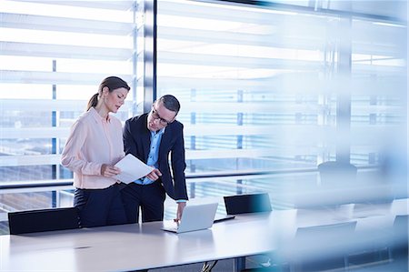 Businesswoman and man reading paperwork at boardroom table Stock Photo - Premium Royalty-Free, Code: 649-08924440