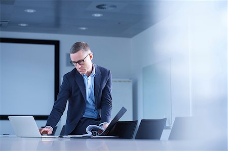 simsearch:649-07238396,k - Businessman typing on laptop at boardroom table Stock Photo - Premium Royalty-Free, Code: 649-08924450