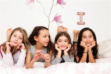 Girls lying on bed resting on elbows looking at camera Photographie de stock - Premium Libres de Droits, Code: 649-08924832