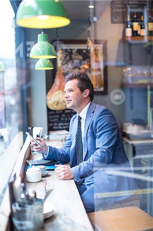 simsearch:649-07520071,k - Mature businessman with smartphone in restaurant window seat Stock Photo - Premium Royalty-Free, Code: 649-08924905