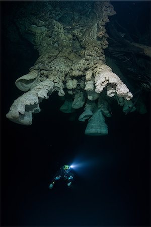 Scuba diver exploring unique natural formations known as "bells" in submerged caves beneath the jungle Stock Photo - Premium Royalty-Free, Code: 649-08922791