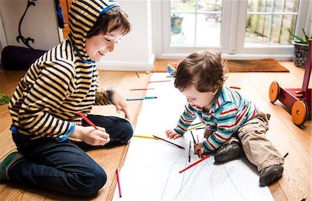 simsearch:695-05770150,k - Male toddler and big brother sitting on floor drawing on long paper Foto de stock - Sin royalties Premium, Código: 649-08922824